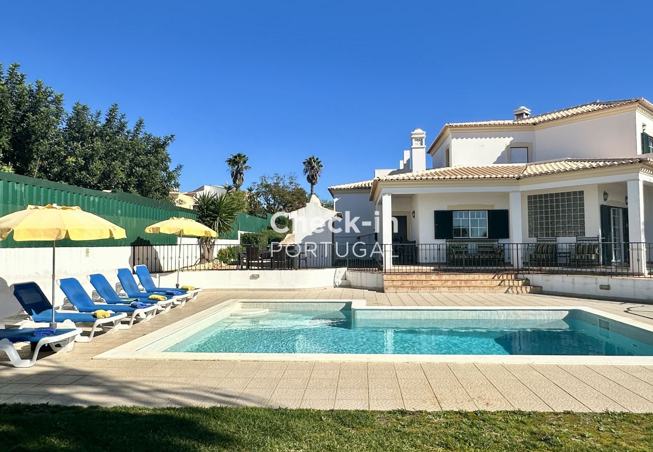 Photographie extérieure d'une maison avec piscine et chaises longues